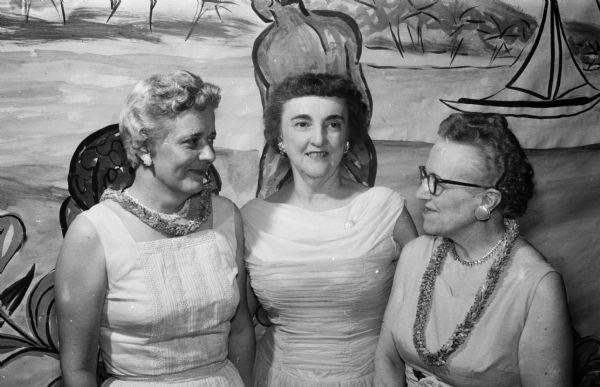 Over 300 members attend the East Side Women's Club annual banquet at the East Side Business Men's clubhouse. The theme of the dinner is "An Evening in Hawaii." Shown (left to right) are Mrs. Gould Morrison, Mrs. Ernest Anderson, and Mrs. Norman Wang.