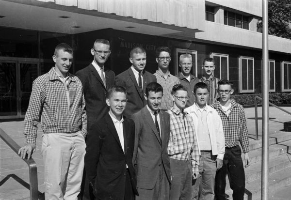 Group portrait of eleven Madison boys ready to leave for Badger Boys State at Ripon College. They represent five Madison high schools. Bottom row left to right: Michael Kurowski, Barry Gaberman, Gary Seymour, Robert Reznichek, and Richard Lenzer.  Top row left to right:  Paul Reisdorf, Luke Groser, John Ihde, Michael Mansfield, Thomas Kroncke, and Barry Olson.