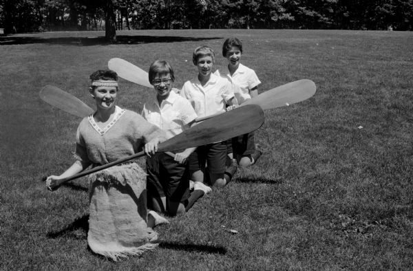 Representatives of the Black Hawk Council of Girl Scouts practice a Native American paddle drill in preparation for a trip to the Round-Up in Colorado. Left to right: Nancy Gibson, Joan Wilkie, Winnie Neil Chapman, and Nancy Muckenhirn.