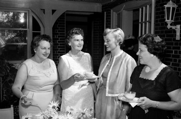 Mrs. Constance Elvehjem, wife of the University of Wisconsin president, visits with three guests at the University League tea held to honor wives of visiting summer session faculty members at the University of Wisconsin. With her are Mrs. Emily Ahearn, Mrs. W.L. Hilsenhoff, and Mrs. Mildred Adolfson.