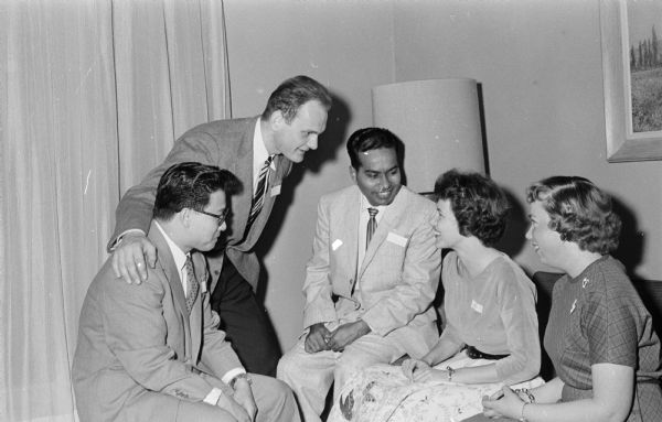 Edgewood College Foreign Students Dinner Two officers of the Edgewood College Mission Club visiting with three foreign students at a dinner that recognized about one-hundred students from other countries. Left to right are Shu Cheuck from Hong Kong, Laszlo Gelencser from Hungary, Krishna Murti from India, club president Mary Kay Schuster, and club secretary-treasurer Madeleine Poster.
