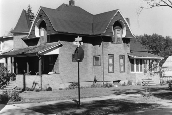 Exterior view of a house at 702 West Olin Avenue. It was built in either 1904 or 1890. Currently many of the architectural details have been removed, but it still has a corner tower and front porch.