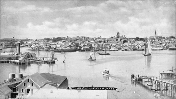 Elevated view of the town and its harbor. Ships are out in the water. Caption reads: "City Of Gloucester, Mass."