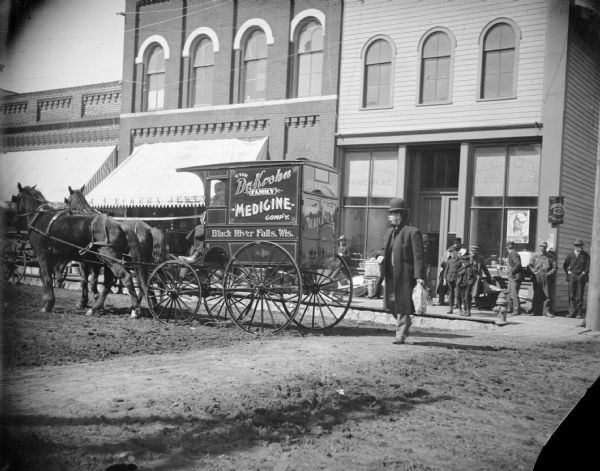 Dr. Eugene Krohn driving his medicine wagon. The man behind the wagon is either Rufus Jones or Warren C. Jones.