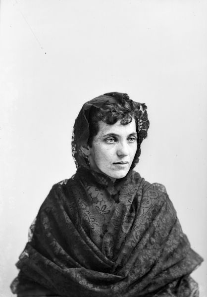Woman Wearing Shawl Studio portrait of a seated woman wearing a lace shawl over her head and shoulders.