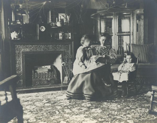 Annie Storer Brown with two children, Eleanore Annie Brown (on her lap), and Alice Brown (in rocking chair), at their home, 121 East Gilman Street.