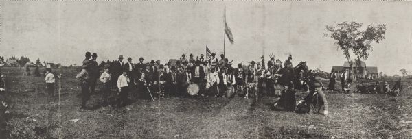 Panoramic image of Chippewa (Ojibwa) Indians at a fair in northern Wisconsin. Caption under the image reads, "Souvenier <i>[sic]</i> of Odanah, Fair 1913." Both American Indians and European settlers pictured.
