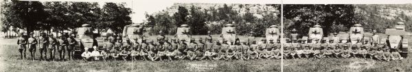 Panoramic view of the 32nd Company W.N.G. (Wisconsin National Guard).  Depicts company members, including two cooks (left panel), and small tanks spaced uniformly throughout the soldiers.