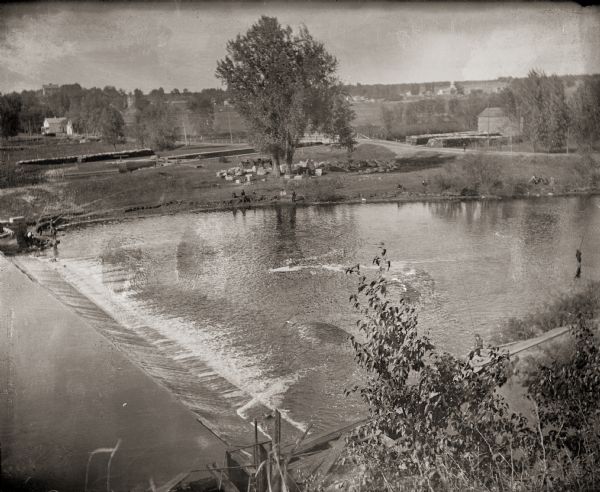 Elevated view of the dam on the Fox River at Buffalo Lake. Houses and other buildings are visible in the background.