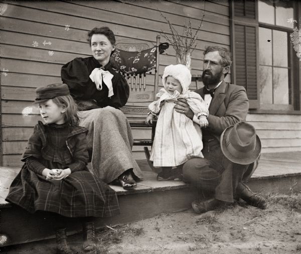 Ada and Dr. Edward A. Bass with their children, daughter Everetta and son Cary, seated on the porch of their home.