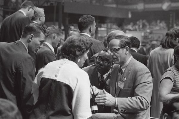 Midge Miller of Madison talking with an unidentified supporter of Eugene McCarthy at the Democratic Convention. Listening intently to their conversation is Hilton Hanna, also of Madison and a leader of the Alamgamated Meatcutters and Butchers of North America.