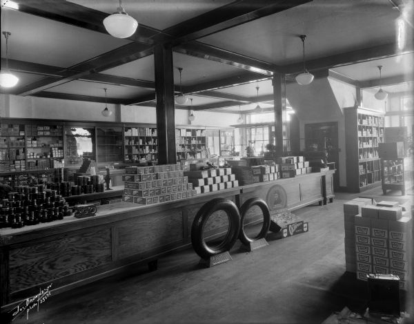 Interior of Firestone Tire Store, perhaps on N. Jefferson Street, north of E. Wells Street. Displays of merchandise including tires, tubes and other auto parts.