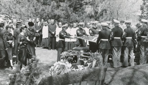 Marine honor guard at the funeral of Senator Joseph R. McCarthy.  Jean McCarthy (wearing a round black hat), stands to the left of the Marines. McCarthy's death created a virtual frenzy among Wisconsin political leaders — both Republicans and Democrats — for election to the senator's unexpired seat. Ultimately Democrat William Proxmire won in a surprise victory that attracted national attention.