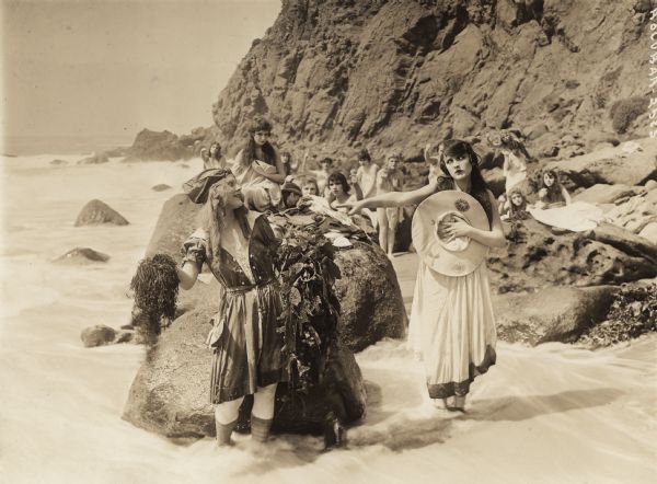 Lorelei (played by Louise Lovely) playfully threatens Julie (Carmel Meyers) with a handful of seaweed as a group of sirens look on in the 1917 Universal production <i>Sirens of the Sea</i>.
