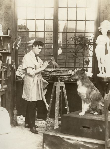 Original caption:
"Universal Actor as Sculptor
Ben Wilson spends leisure hours at favorite pastime--the making of statuary. Here he is modeling a statuette of his pet collie."