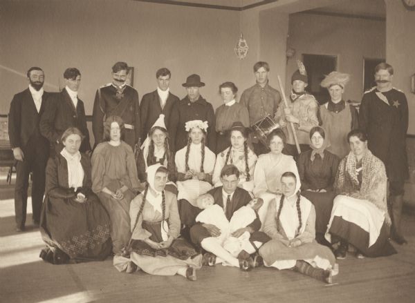 Group portrait of a German party thrown by the junior and senior class at Menomonie High School. Students are dressed as famous German figures or in traditional German costume. Part of a yearbook created by classmate Albert Hansen, based on a class prophecy theme.