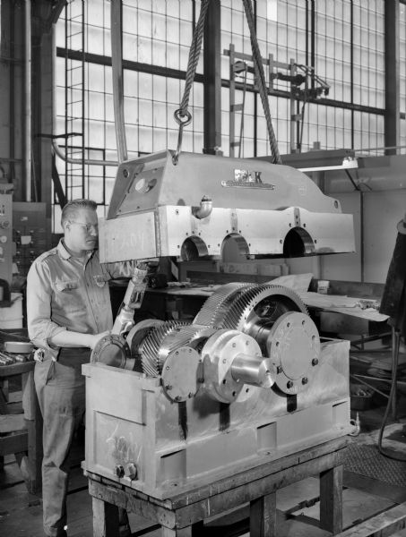 Ron Kudlewski, a Falk employee, attends to the test stand for large motors in the High Speed Department. This motor was later purchased and used by the Louis Allis Company. Falk caption reads, "5000 HP unit 1800/3600 rpm."