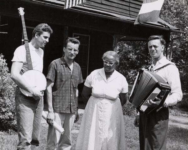 A meeting at Highlander Folk School. Guy Carawan is holding a banjo on far left. Septima Clark is standing third from the left. Matt Sturgis, holding an accordion, is standing on the extreme right.