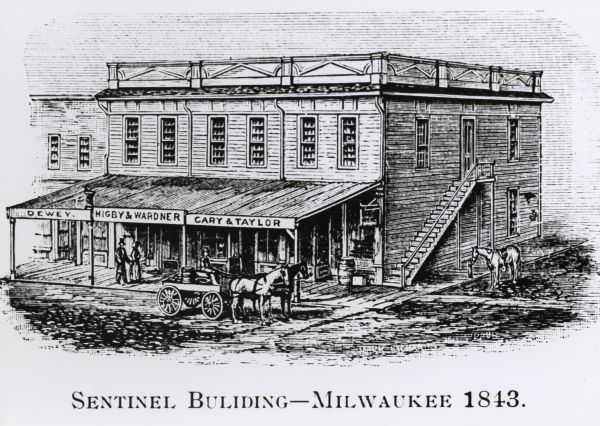 Exterior of two-story wood building at the corner of Wisconsin and Water Streets.  The first floor consists of businesses run by Dewey, Highby & Wardner, and Cary & Taylor. The <i>Milwaukee Sentinel</i> office was on the second floor of this building. A horse is tied to the post at the right, and a cart stands in front of the building.  A couple is walking on the board sidewalk.