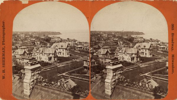 Stereograph of a view over rooftops of a neighborhood near Lake Michigan. Shoreline can be seen in the background.
