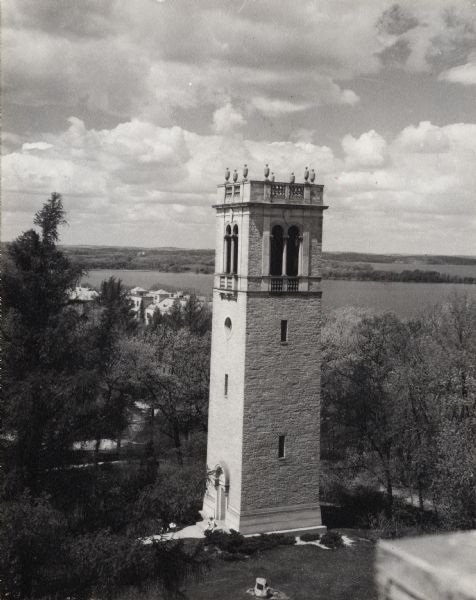 Elevated view from building of Carillon Tower on the University of Wisconsin-Madison campus. Lake Mendota and Picnic Point are in the background. There is a plaque on a rock near the entrance to the tower.