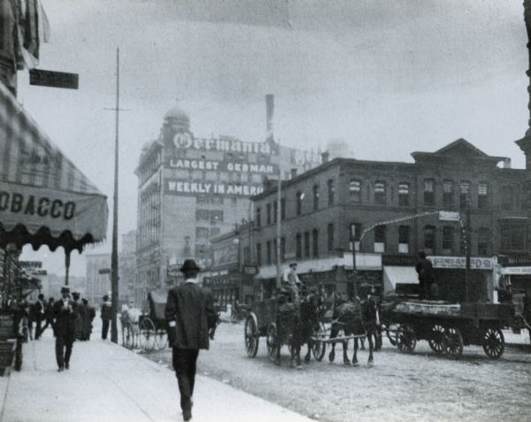 Traffic on Wells Street with the Germania Newspaper weekly building in the background.