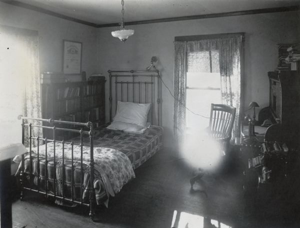 Richard Lloyd Jones's bedroom, 1010 Walker Court (now 1010 Rutledge Court) , view of bed with reading light over it.  His large desk, telephone and Underwood typewriter are on the right.  Richard Lloyd Jones was editor of the Wisconsin State Journal from 1911-1919.