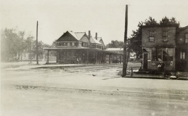 Illinois Central Railroad Station Illinois Central Railroad station. Automobiles and a horse-drawn wagon are parked beneath the canopy. In the right foreground is a commercial building with a man and boy looking in the window of the storefront.