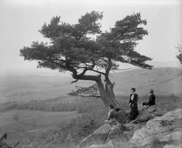 Two women and a man pose atop Gibraltar Rock in Richmond Memorial Park, which was dedicated by Jens Jensen and the Wisconsin Friends in 1927 in order to conserve the native landscape. The Wisconsin River is visible in the background.