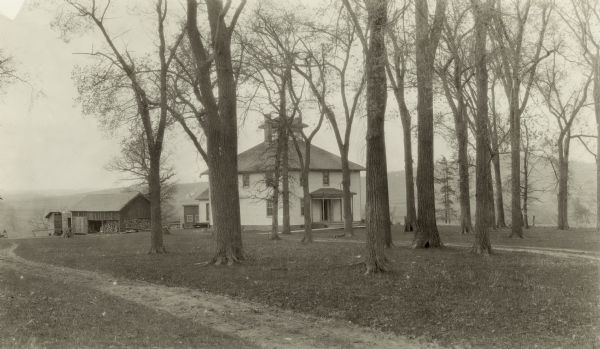 The hotel is set in a grove of trees against a backdrop of rolling hills. There are two chimneys and a belvedere. There is a barn behind with a supply of fire wood.