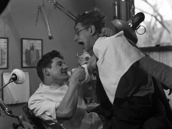 While waiting for the dentist, William Powell and Robert Bloch pre-enact the struggle. Both Bloch and Gauer had many medical emergencies in their lives due to the lack of funds during the depression.