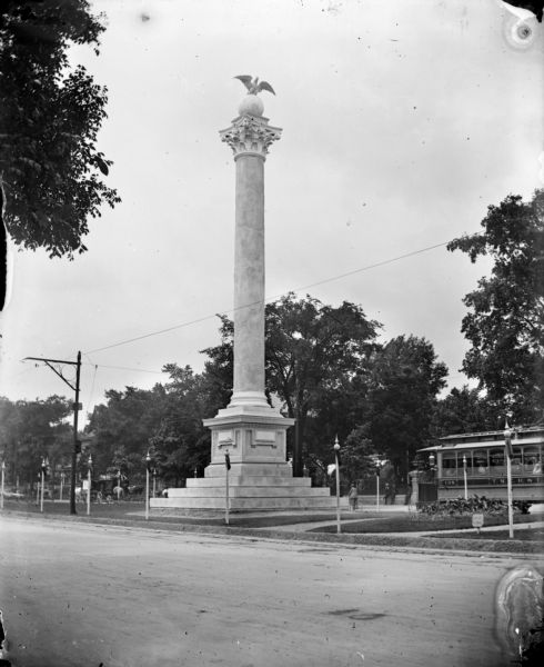 View from across street of the Midsummer Festival Monument in the Court of Honor on the median of Grand Avenue. An electric street car is visible in the background.
