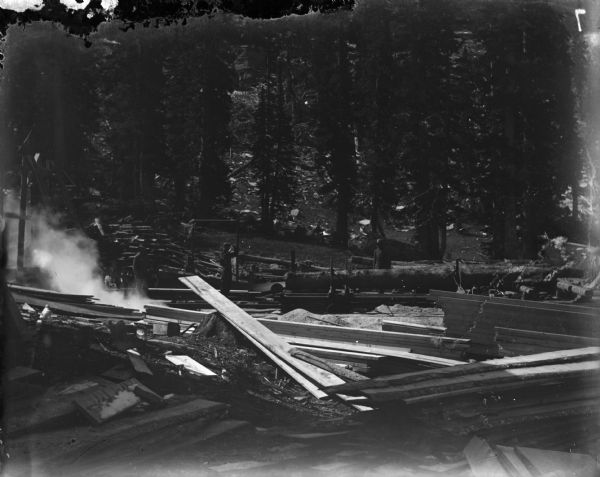 Workers at the Leighton-Wyoming mining camp. Piles of logs and boards are in the foreground.