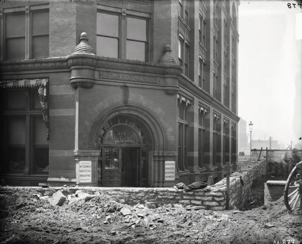 Entrance of an office building of the McCormick Harvesting Machine Company at 212 Market Street. The street around the building is full of rubble and appears to be under construction.