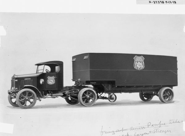 Left side view of an International fleet truck for the "Union Pacific Systems" company. The trailer of the truck as well as the door have the company emblem with the wording: "Union Pacific Systems Overland." Original notes at the bottom of the image are crossed out and read: "Bring out Union Pacific trade-mark layer & stronger."