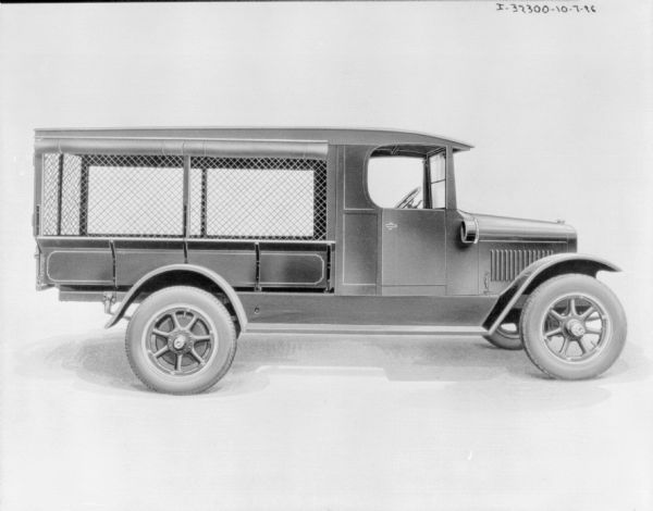 Truck Right side profile view of truck. The truck bed is covered, and the sides have screens. A canvas cover is rolled up at the top of the roof.