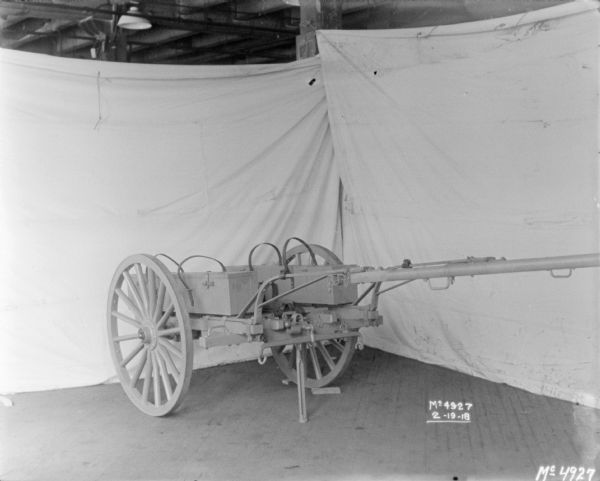 Gun Cart Loaded with Crated Guns Gun Cart on factory floor surrounded by backdrops.
