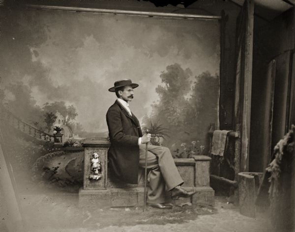 Charles J. Van Schaick sitting on a stone balustrade in front of a painted background, ca. 1882–1885. The photograph was probably taken by one of his assistants, Louis Sander, A.R. Cottrell, or S. Wohl.
