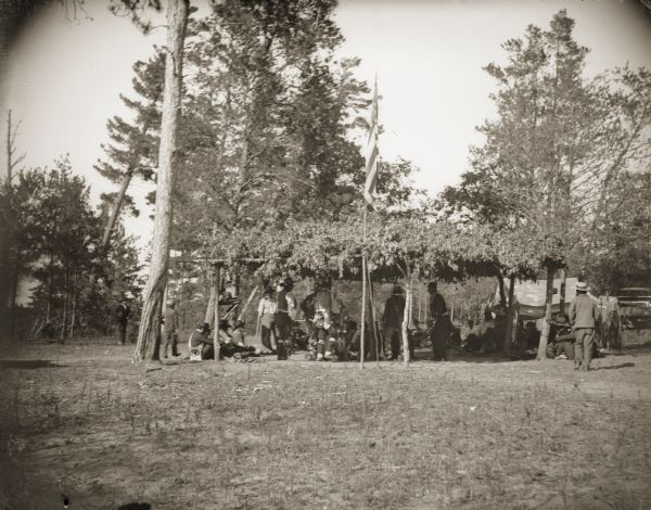 This arbor was erected for a celebration with the Ojibwe, who traveled from their reservation in northern Wisconsin to participate in the Winnebago-Chippewa Conference of 1895 and to present the Ho-Chunk with a ceremonial drum. Arbors were often used for powwows. Singers would sit around a drum in the center of the arbor, and the dancers would dance in a circle around the drum and singers. At a large powwow, only the drums and singers could fit under the arbor and the dancers would dance around the arbor. An American flag is flying from a pole at the front of the arbor.