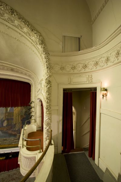 Decorative plasterwork in the Mineral Point Opera House showing stage and painted curtain in background.