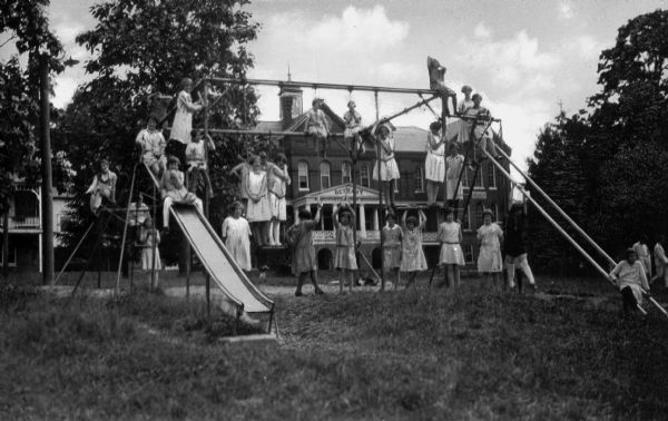 Children outdoors on playground equipment, including a slide, at Bethany Orphan Home.