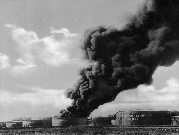 An oil tank burns in Tulsa, a city that had earned the title "Oil Capital of the World" and whose population grew to 72,000 by 1920. The Texas Company was founded in 1901 and became the first U.S. oil company to sell its gasoline nationwide under one single brand name in every state.