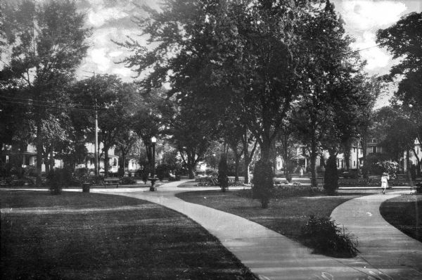 Wilson Park View of Wilson Park. A woman walks on a path that leads to the right, and houses are in the background.