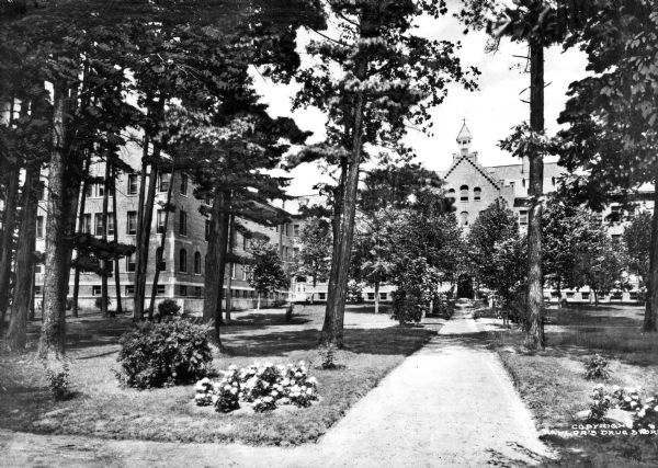 Sisters of St. Joseph of the Third Order of St. Francis Motherhouse View of the motherhouse at the Sisters of St. Joseph convent in Stevens Point. A path leads to brick convent buildings across a lawn with trees, shrubs, and flowers.