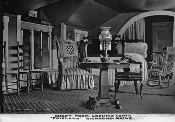 Bedroom featuring an elaborately carved bed, a table with an embellished lamp, and chairs in a guest room. Caption reads: "Guest Room, Looking North 'Fairlawn' Richmond, Maine."