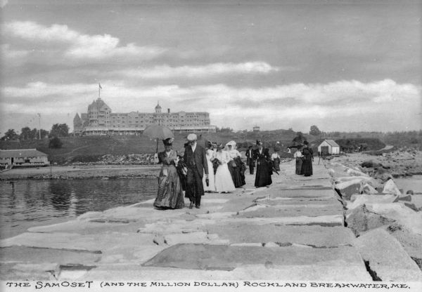 A group of adults, mostly women, walk along the Rockland Breakwater. The Samoset Resort is in the background on the shoreline. Caption reads: "The Samoset (and the million dollar) Rockland Breakwater, ME."