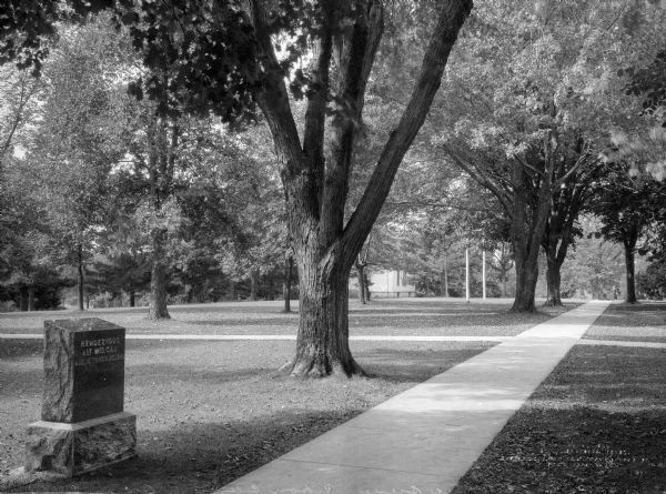 A view of campus green space at Ripon College. A commemorative stone marker in the foreground has text that reads: "Rendezvous 1st Wis. Cav. Aug. 15 to Nov. 23, 1851."