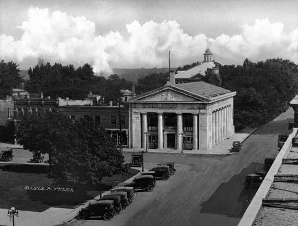 Elevated view of automobiles parked in front of the First National Bank building.