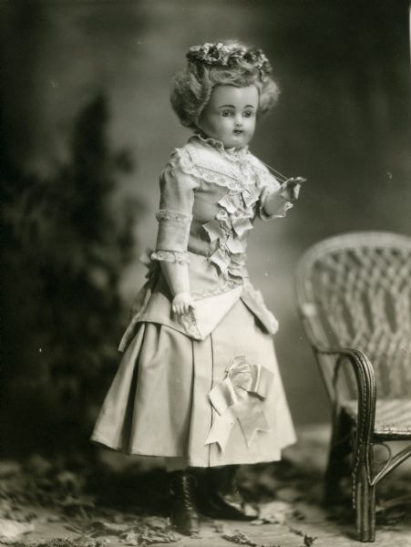 A portrait of the doll, Violet, from the collection of the photographer's wife, Alice Kent Trimpey. The doll has a wax-over-composition head and is described on the negative jacket as having been "made in a Paris shop."