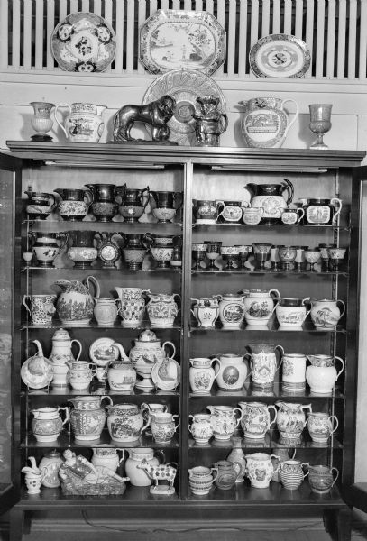 An open cabinet in the photographer's home displays his collection of lustreware and other pottery. The collection is now owned by the Wisconsin Historical Museum.
